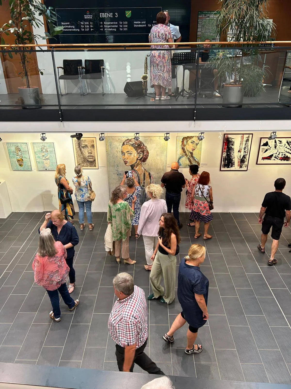 Ausstellung in St. Michael ob Bleiburg — Besucher vor großformatigen Gemälden